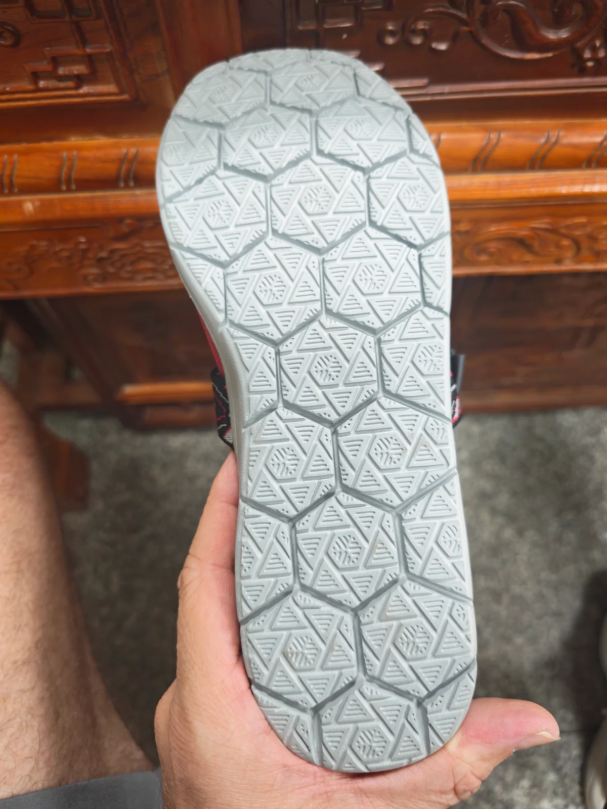 Close-up of a court shoe outsole showing hexagonal grip tread pattern